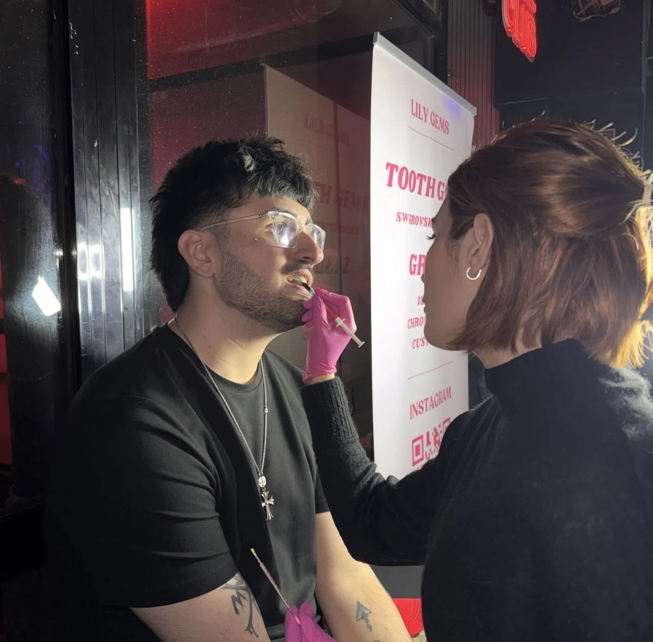 Técnica de Lily Gems poniendo tooth gems en discoteca de Barcelona